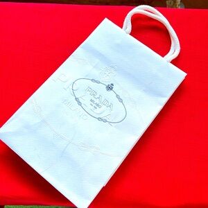 Paper PRADA gift bag. White with blue logo.